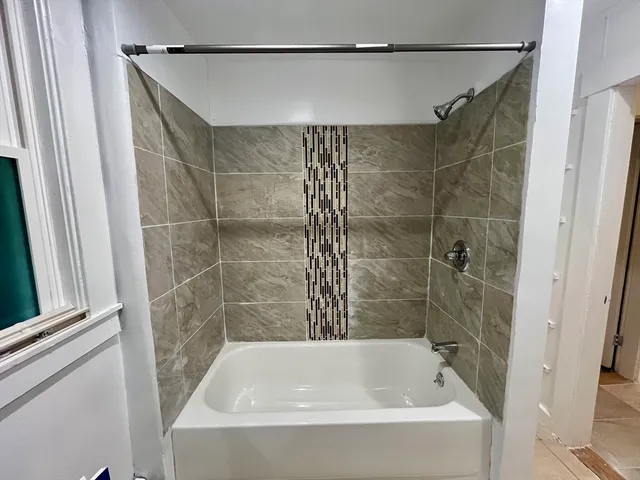 a bathroom with a shower and a bath tub