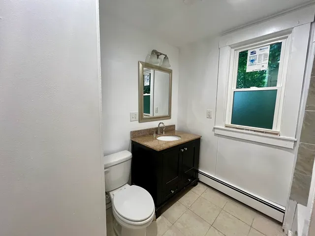 a bathroom with a toilet sink vanity and mirror