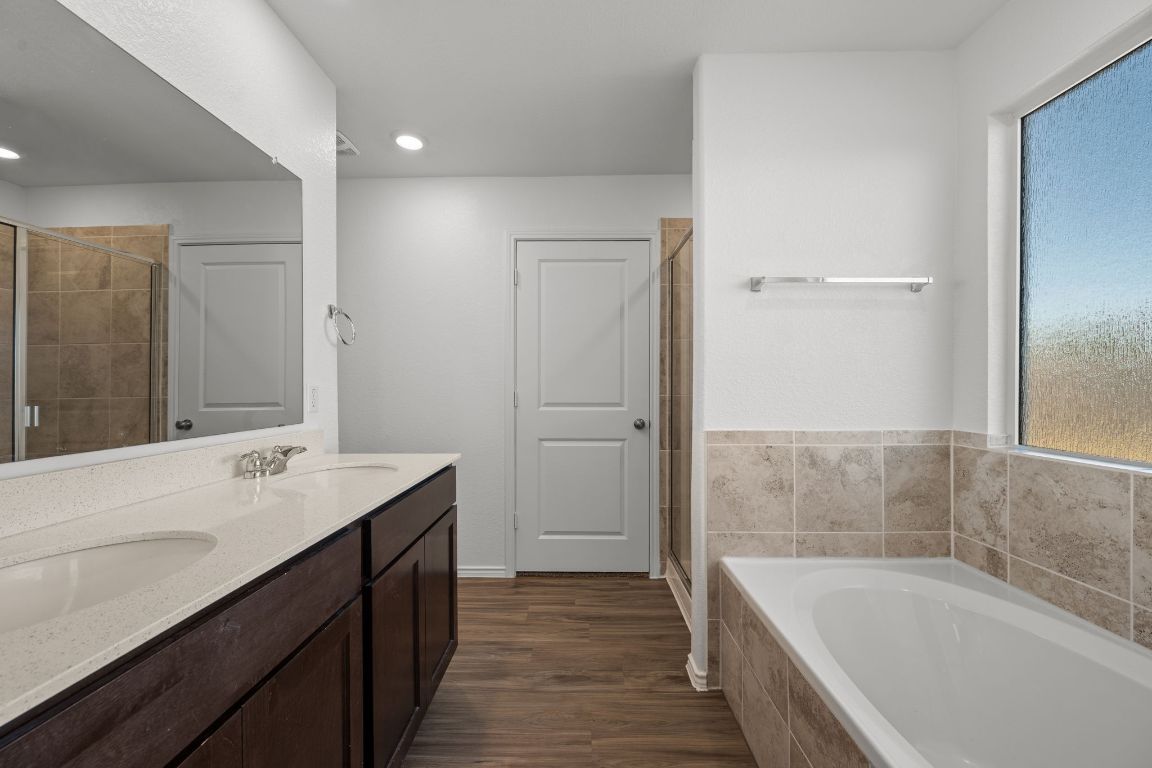 3206 Dusted Daisey Street Pflugerville, TX 78660 - Photo 12 of 25 a bathroom with a tub sink and mirror
