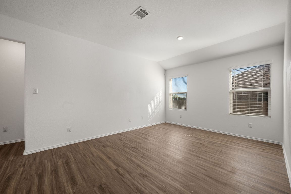 3206 Dusted Daisey Street Pflugerville, TX 78660 - Photo 4 of 25 a view of an empty room with wooden floor and a window