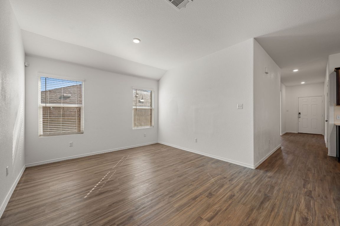 3206 Dusted Daisey Street Pflugerville, TX 78660 - Photo 5 of 25 a view of an empty room with wooden floor and a window