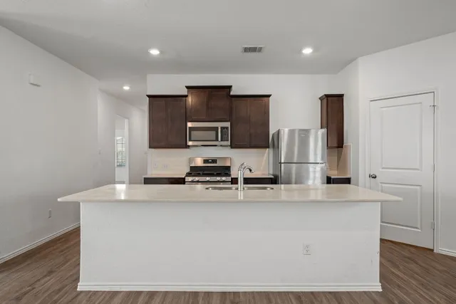 a kitchen with kitchen island white cabinets and stainless steel appliances