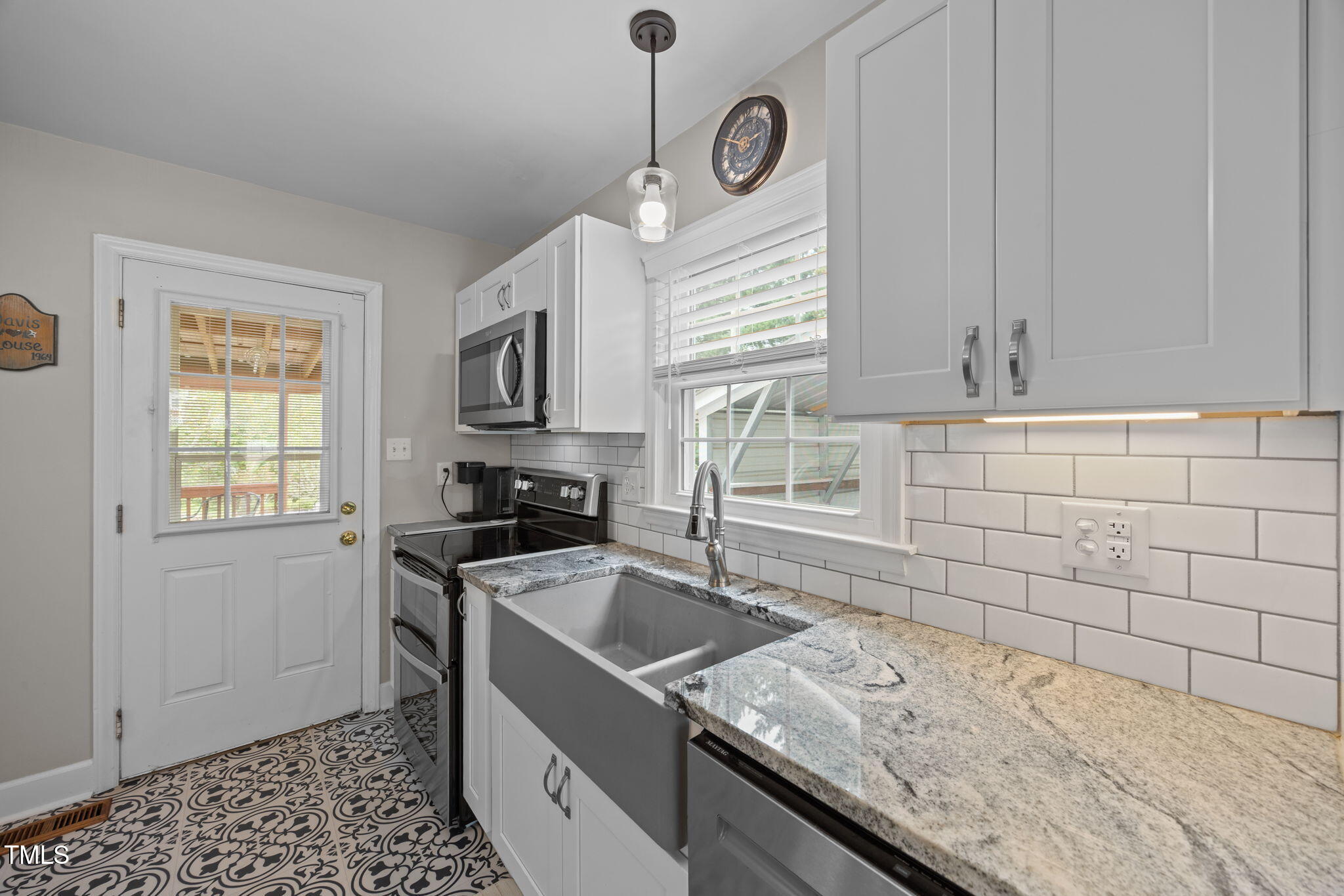 407 North 9th Street Mebane, NC 27302 - Photo 13 of 42 a kitchen with granite countertop a sink a stove and cabinets