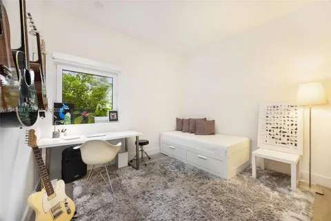 a room with a bed a lamp and a window