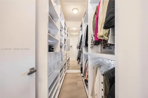 a view of walk in closet with clothes and shoes