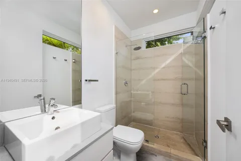 a bathroom with a white sink a toilet and shower