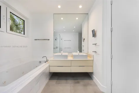 a bathroom with a bathtub and a double vanity sink