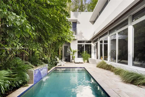 a view of an house with swimming pool and porch with furniture