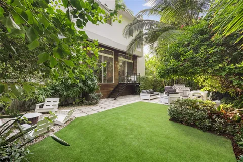 a view of a patio with couches table and chairs potted plants with large tree