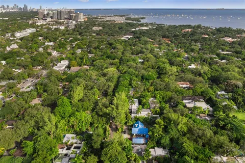 a view of a city with lush green forest