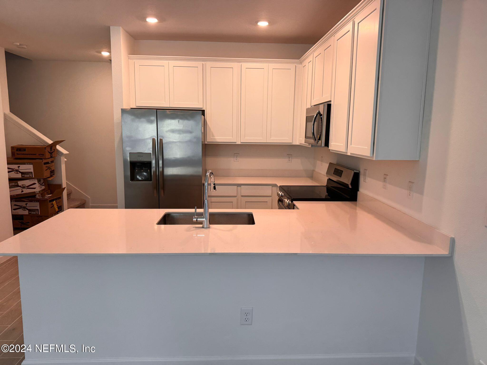 362 Belfort Court St. Augustine, FL 32092 - Photo 2 of 29 a kitchen with kitchen island a stove a sink and a refrigerator