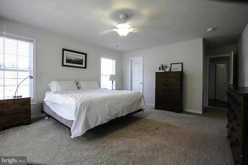 803 Sunken Road Fredericksburg, VA 22401 - Photo 15 of 23 a spacious bedroom with a bed and a chandelier