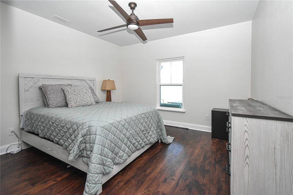 7890 Southwest 129th Avenue Cedar Key, FL 32625 - Photo 30 of 45 a bedroom with a bed and wooden floor