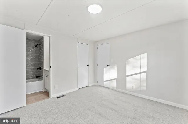 an empty room with windows and closet