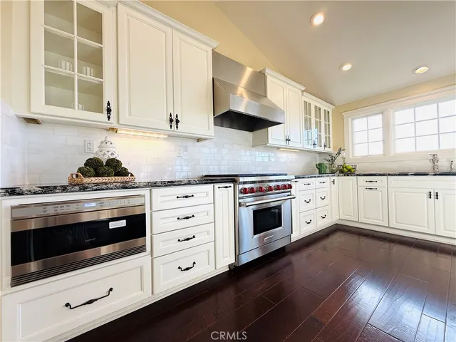 a kitchen with stainless steel appliances a stove a sink and a microwave