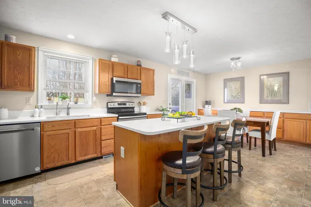a kitchen with cabinets a sink dining table and chairs
