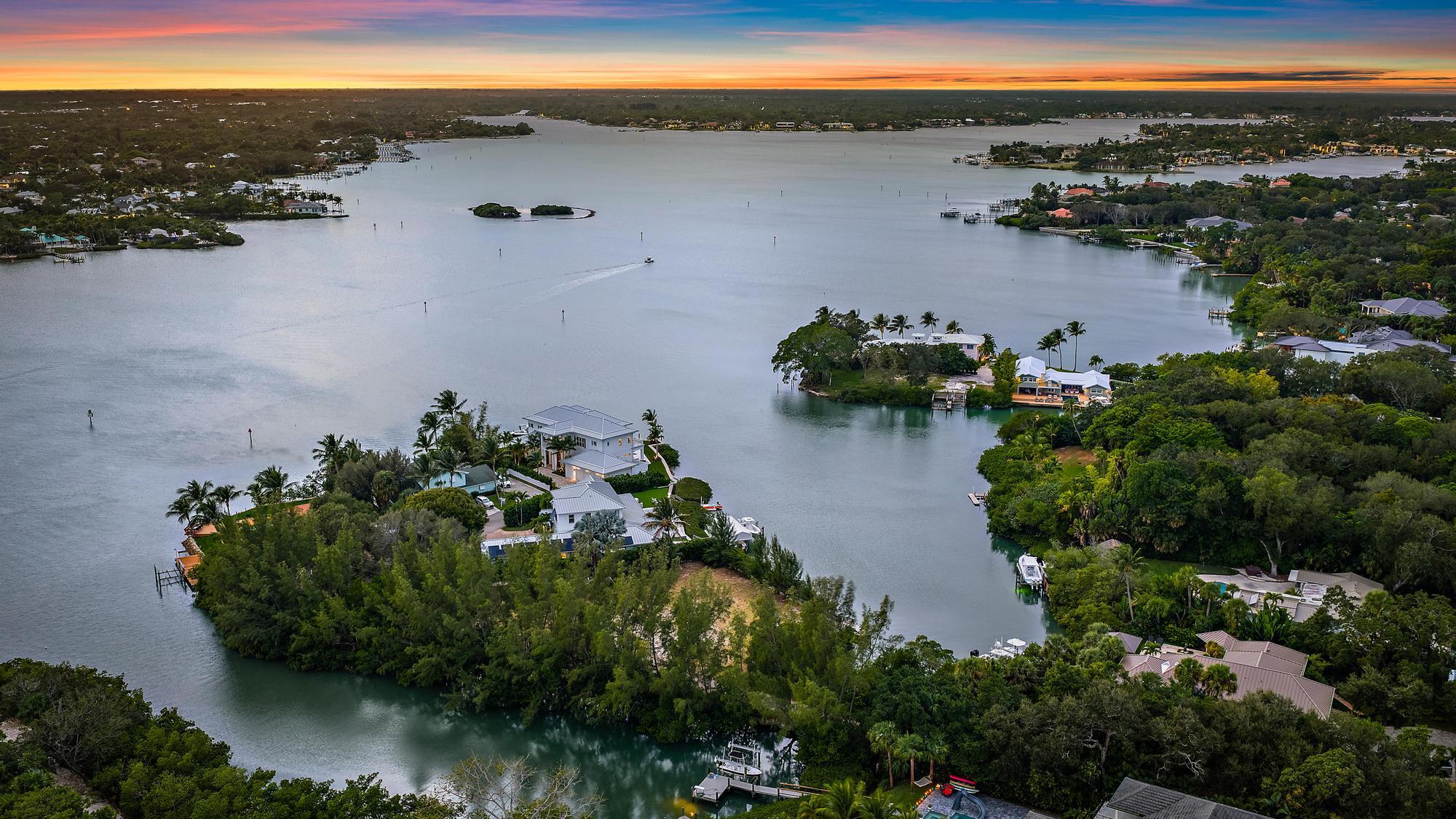1310 Peninsular Road Jupiter, FL 33469 - Photo 12 of 17 an aerial view of ocean with residential house with outdoor space and trees all around