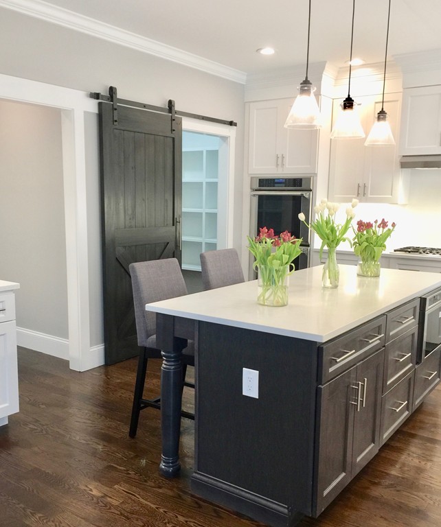 67 Evelyn Road Needham, MA 02494 - Photo 3 of 13 a kitchen with kitchen island stainless steel appliances a dining table chairs sink and cabinets