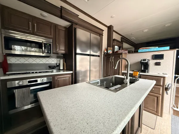 a kitchen with stainless steel appliances granite countertop a sink a stove and a refrigerator
