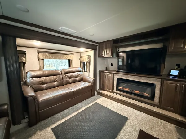 a living room with furniture a flat screen tv and a fireplace