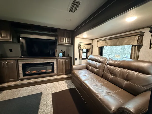 a living room with furniture a flat screen tv and a fireplace