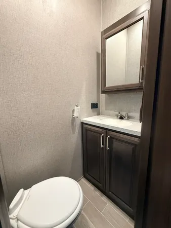 a bathroom with a toilet sink and mirror