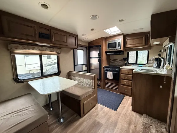 a kitchen with stainless steel appliances granite countertop a stove a sink dishwasher and a microwave oven with large wooden cabinets