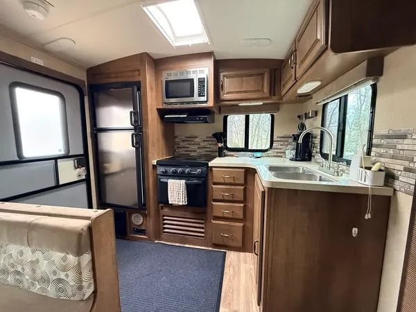 a kitchen with stainless steel appliances kitchen island granite countertop a refrigerator a stove and a sink with cabinets