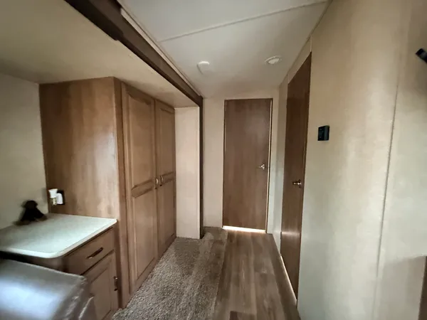 a view of a hallway to a livingroom with furniture