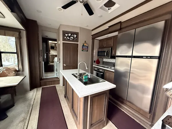 a kitchen with kitchen island a counter top space a sink a refrigerator and washer