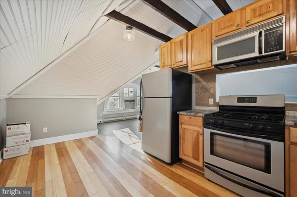 a kitchen with stainless steel appliances granite countertop a stove and a white cabinets