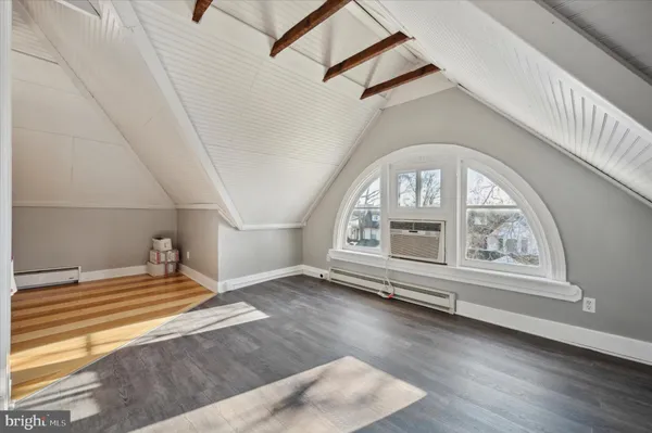 an empty room with wooden floor and white walls