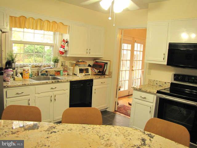 10277 Gainsborough Road Potomac, MD 20854 - Photo 7 of 14 a kitchen with stainless steel appliances a stove sink and microwave