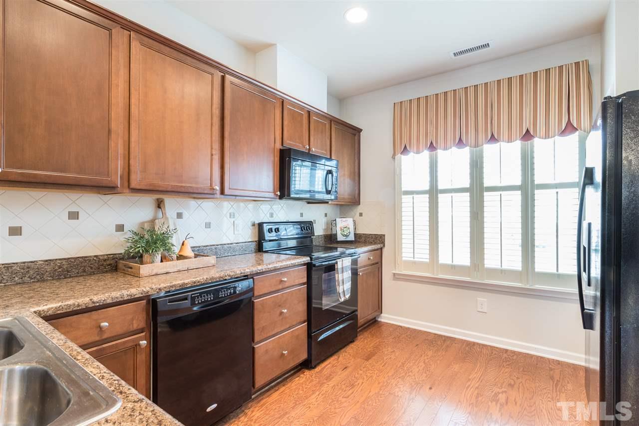 3106 Berkeley Springs Place Raleigh, NC 27616 - Photo 5 of 26 a kitchen with stainless steel appliances granite countertop a stove a sink and a microwave