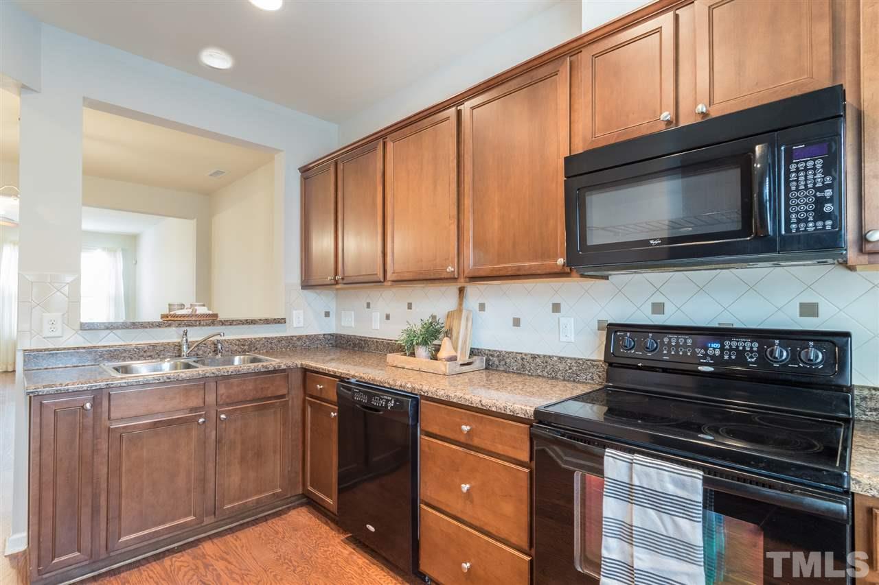 3106 Berkeley Springs Place Raleigh, NC 27616 - Photo 6 of 26 a kitchen with stainless steel appliances a stove microwave and sink