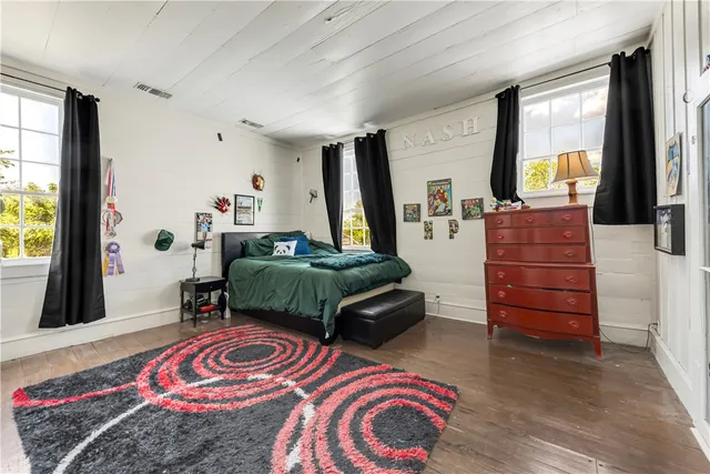 a bed sitting in a bedroom next to a lamp