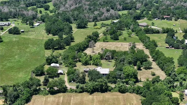 an aerial view of residential house with outdoor space and trees all around