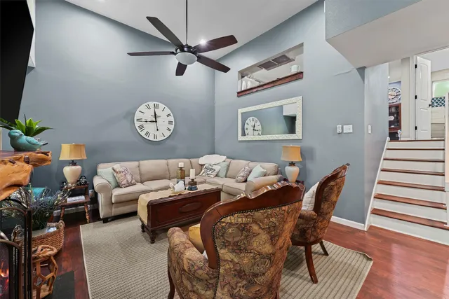 a living room with furniture a clock and a flat screen tv