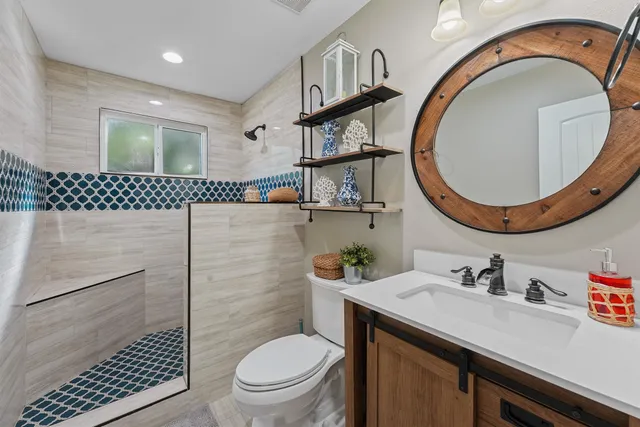 a bathroom with a sink a toilet and a mirror