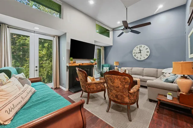 a living room with furniture a flat screen tv and a large window