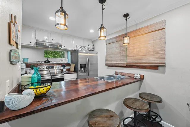 a kitchen with stainless steel appliances granite countertop a sink a stove and a wooden floors