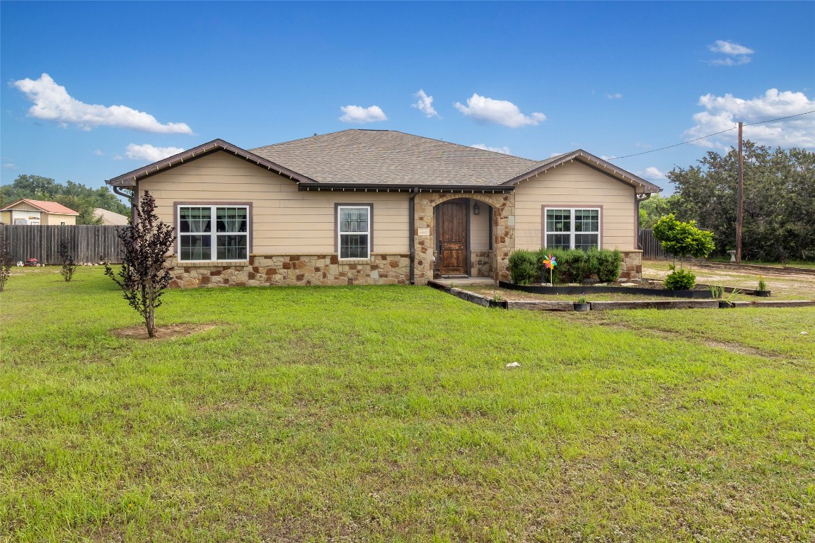 a view of a house with a yard and fence