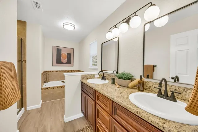 a en suite bathroom with a granite countertop sink and a mirror