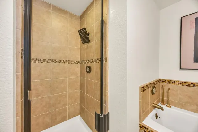 a view of an empty room and chandelier fan