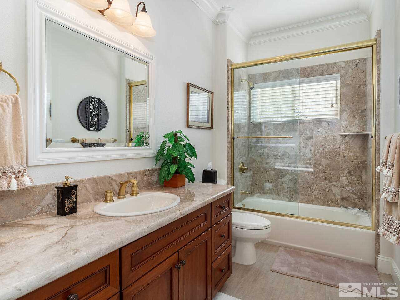 1345 View Crest Court Reno, NV 89511 - Photo 24 of 40 a bathroom with a granite countertop sink a toilet a mirror and shower