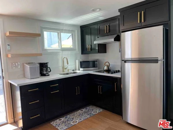 a kitchen with a refrigerator sink and cabinets
