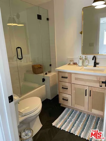 a bathroom with a granite countertop toilet sink and mirror