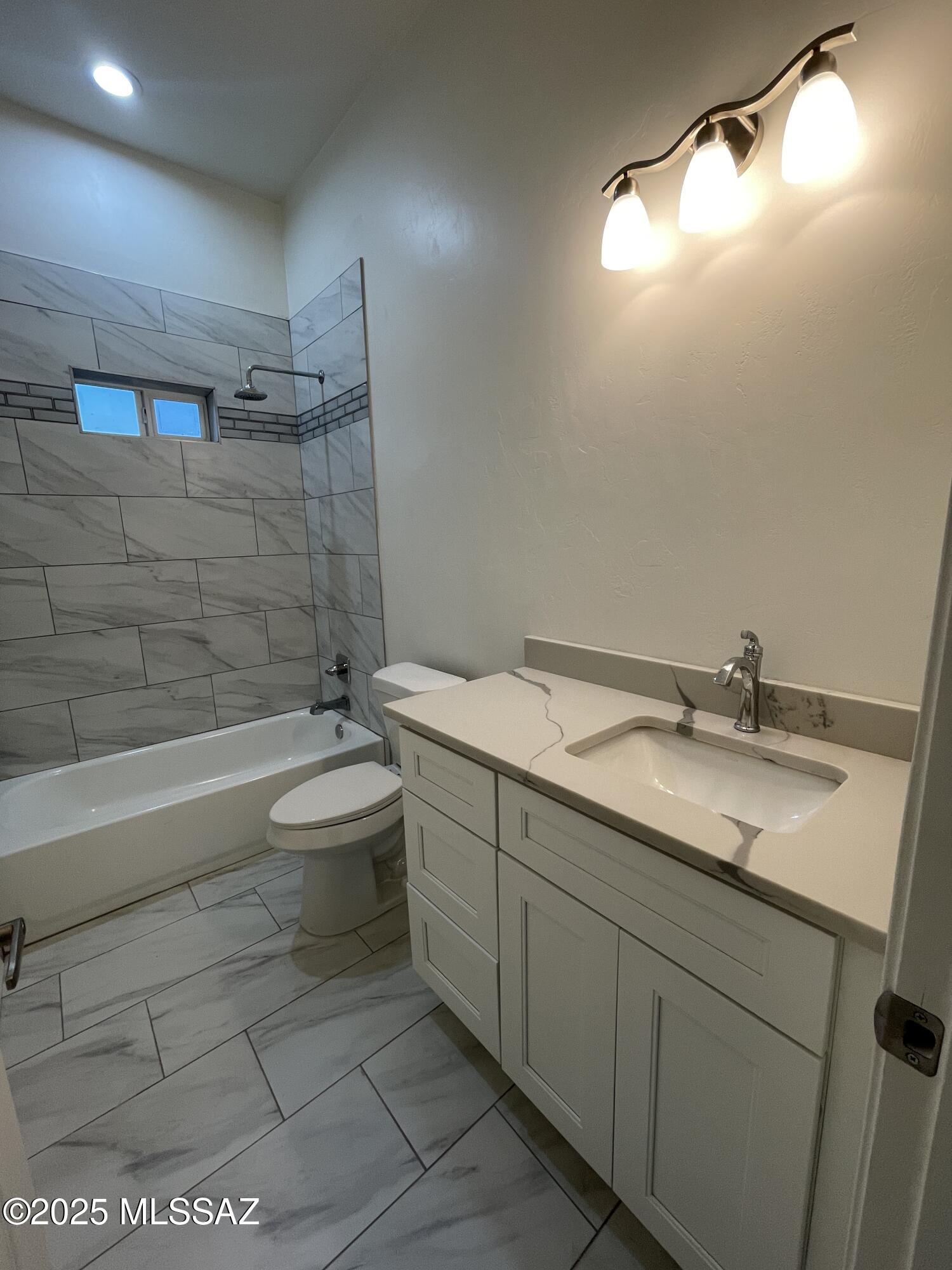 87 Avenida Pastor Rio Rico, AZ 85648 - Photo 20 of 24 a bathroom with a granite countertop sink a toilet and bathtub