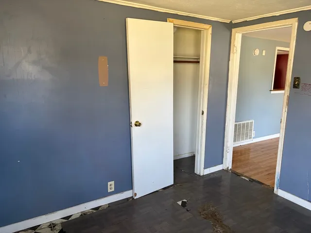 an empty room with windows and closet
