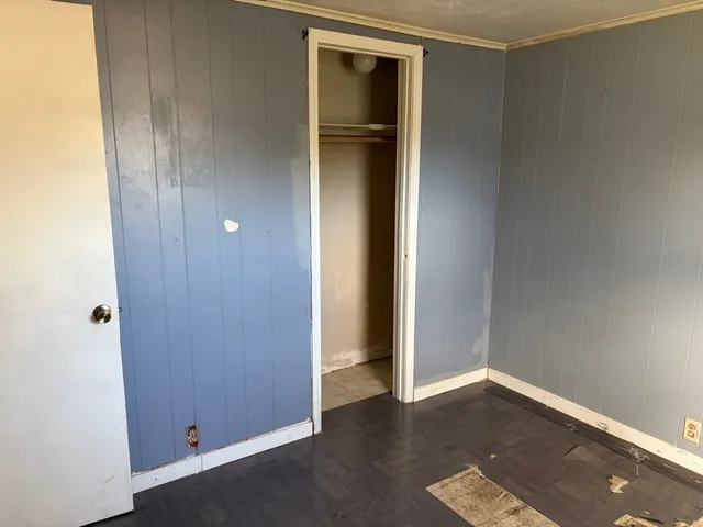 an empty room with wooden floor and closet